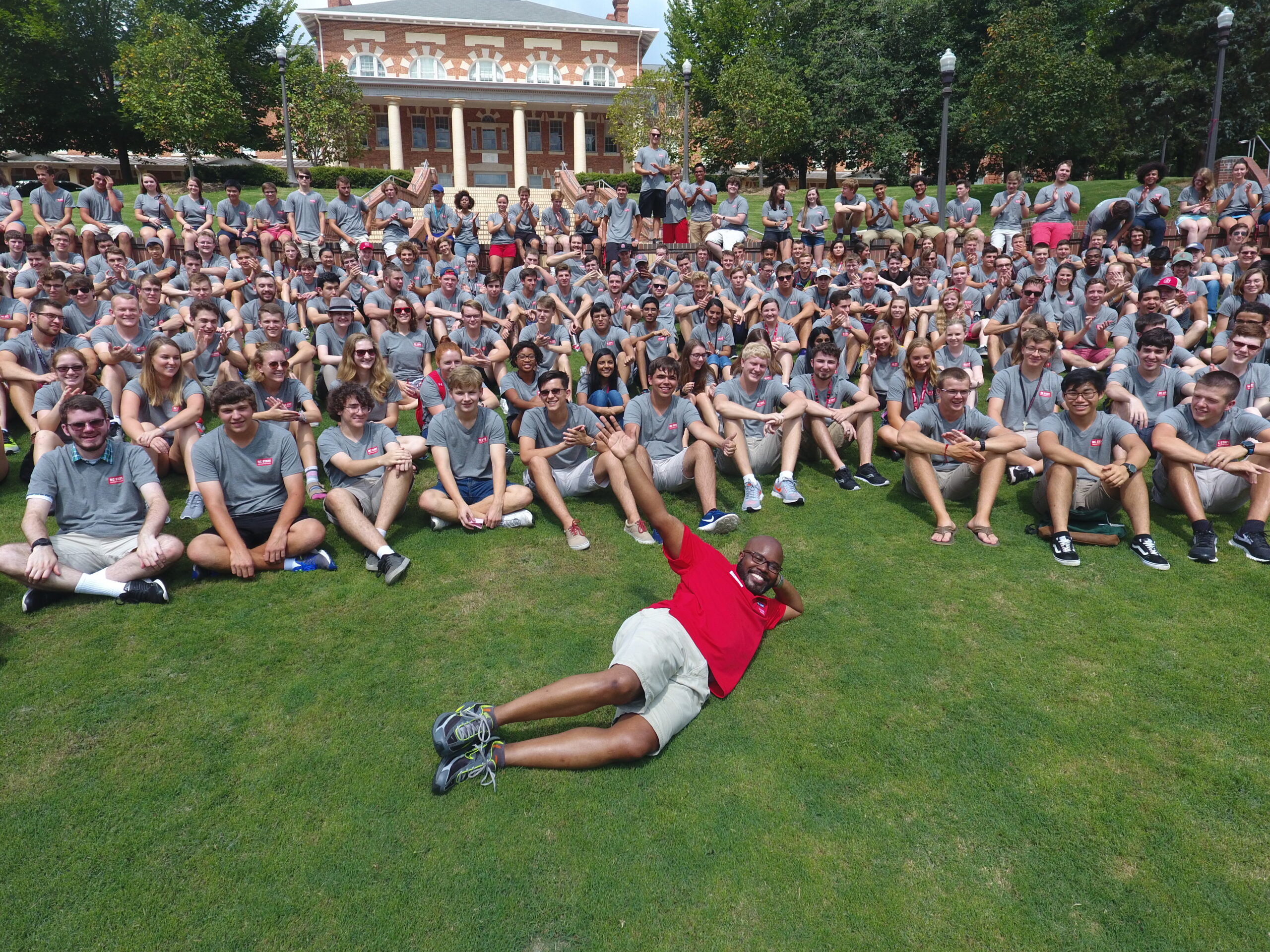 University Housing staff member poses with students on Quad.