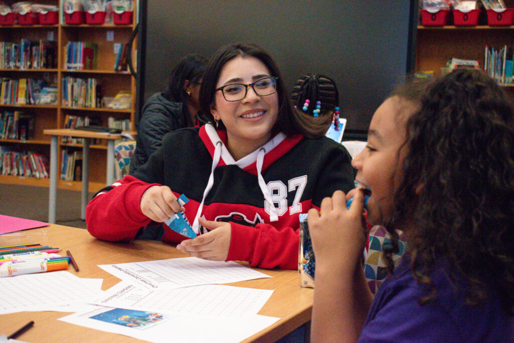 SAY residents working with an elementary student in an after school program. 